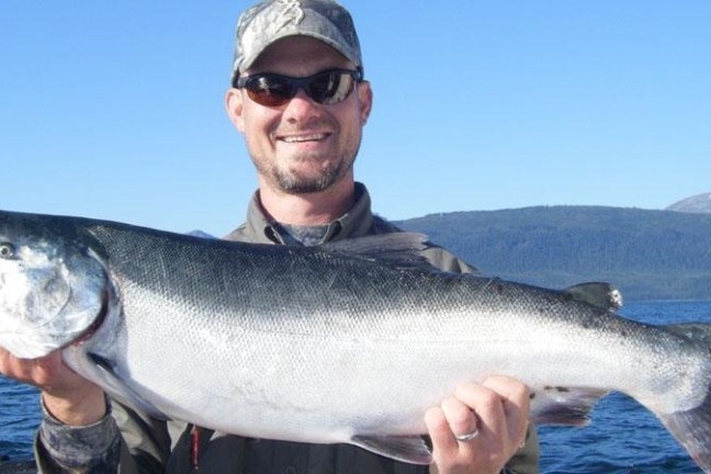 a man holding a fish in the water