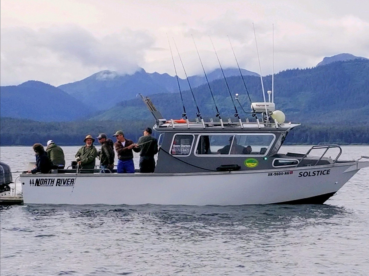 A group of people on a power boat in Juneau fishing
